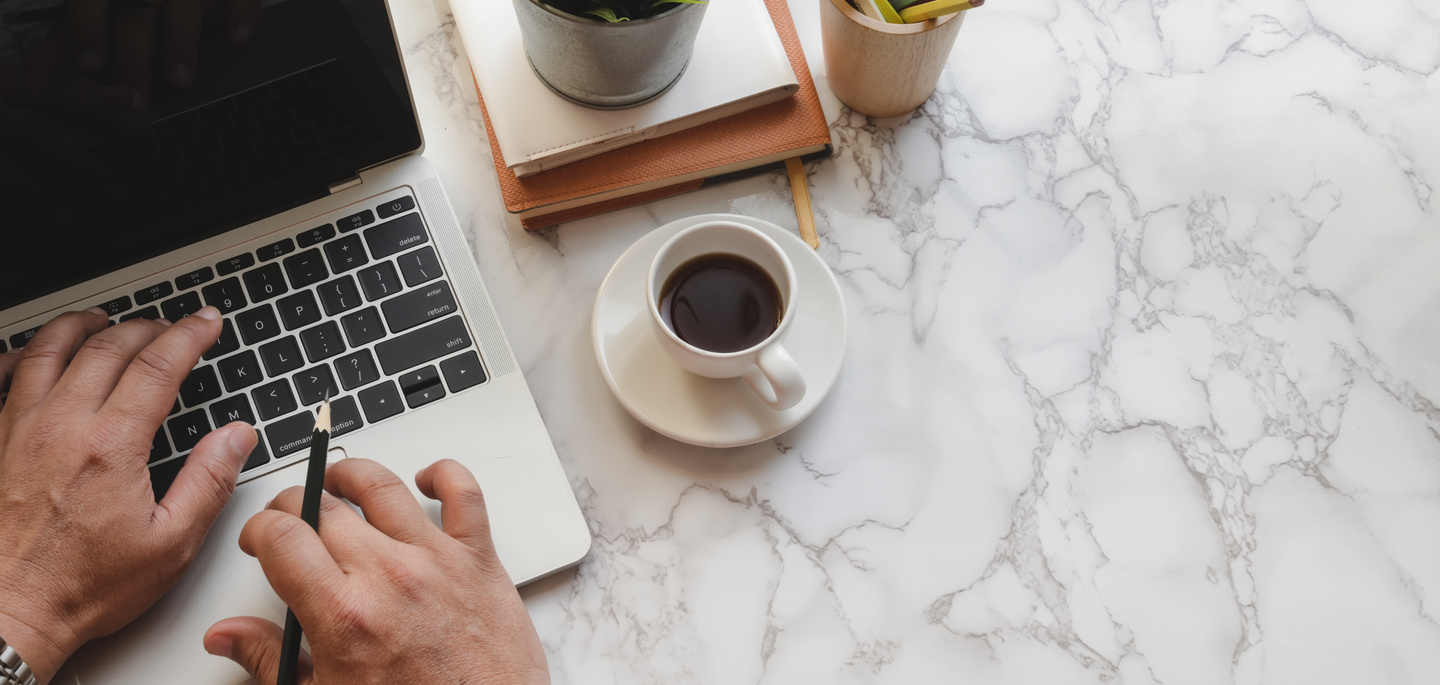Anonymous man working on laptop having coffee